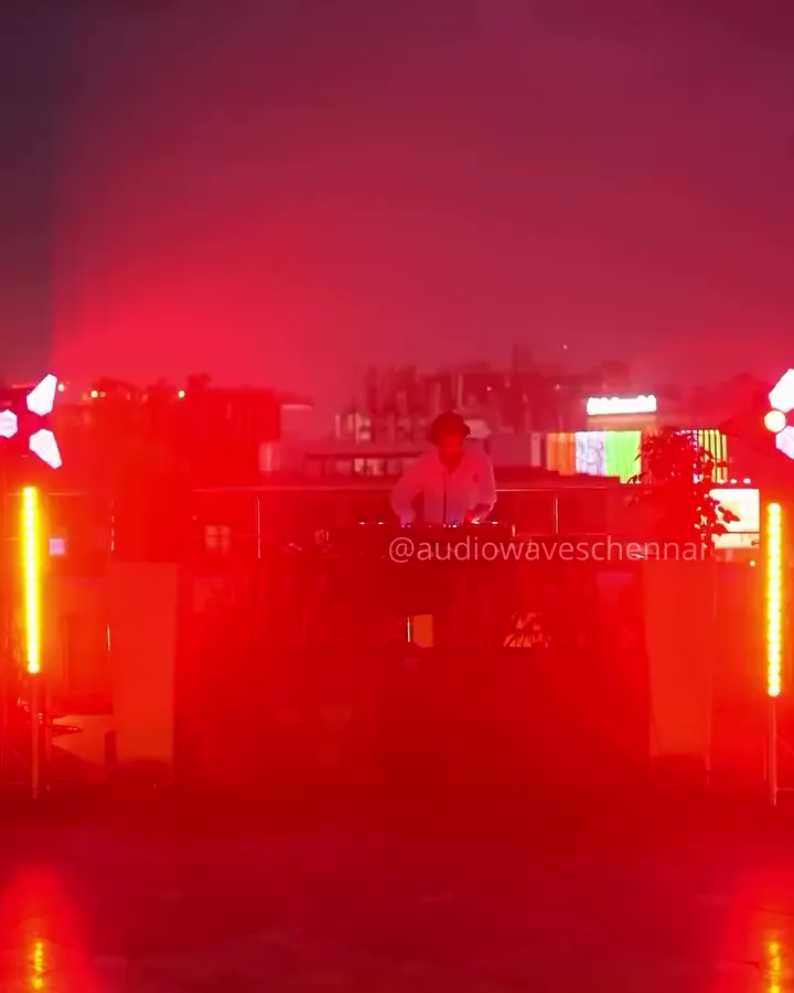 Rooftop DJ setup at night with pink and red uplights, Taj Club House Chennai