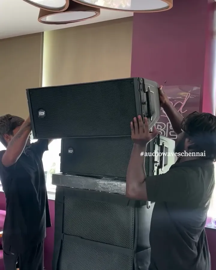 Crew stacking line-array speakers during setup